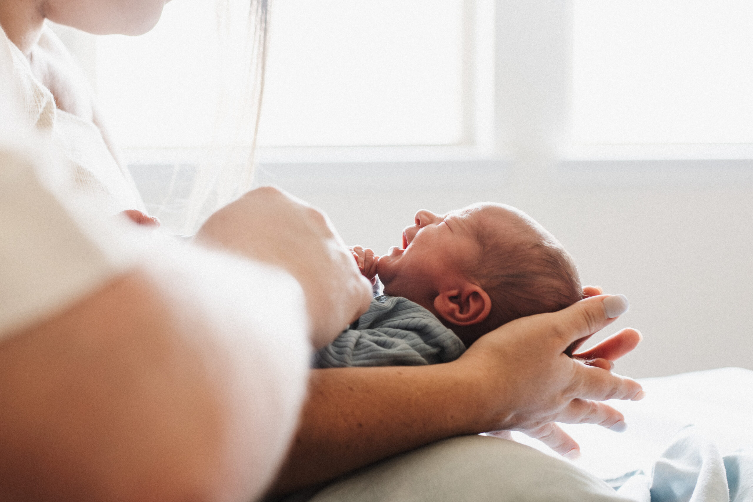 a newborn baby is held by his mother after just being born in dallas