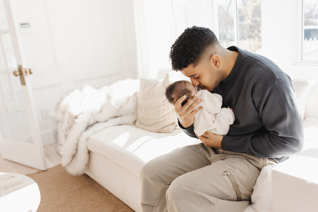 Lifestyle newborn session in McKinney Texas home with father cradling sleeping newborn baby