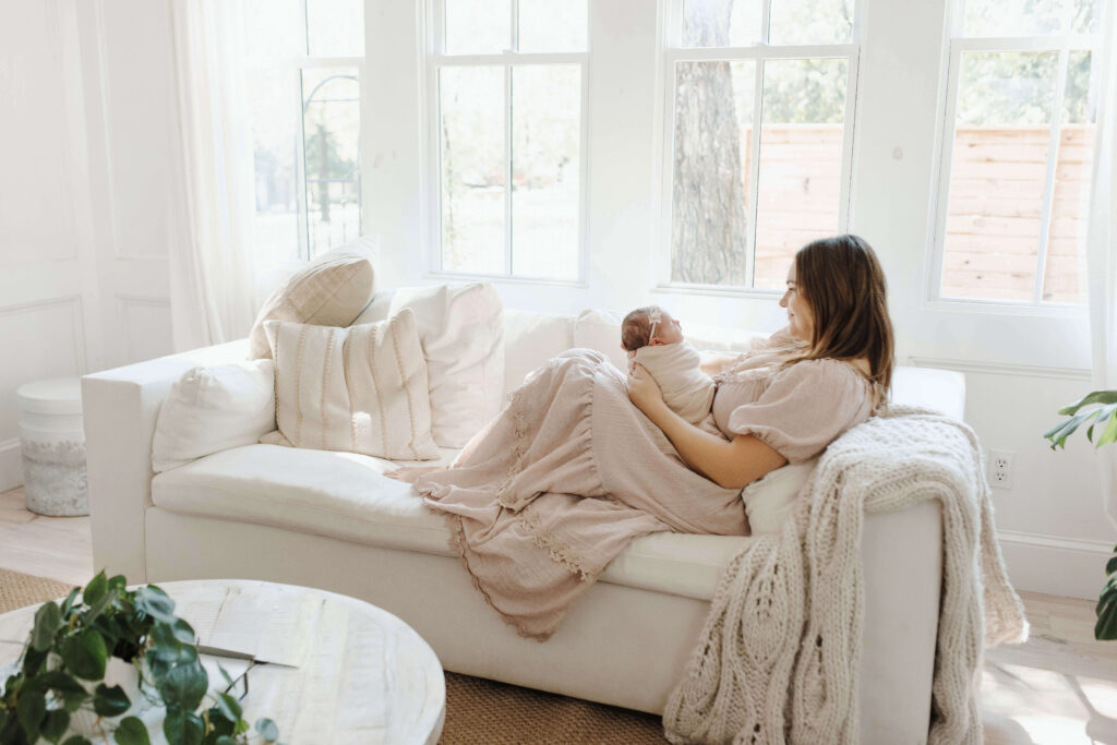 Denton newborn photographer capturing mother and newborn baby in soft natural light during in-home lifestyle session