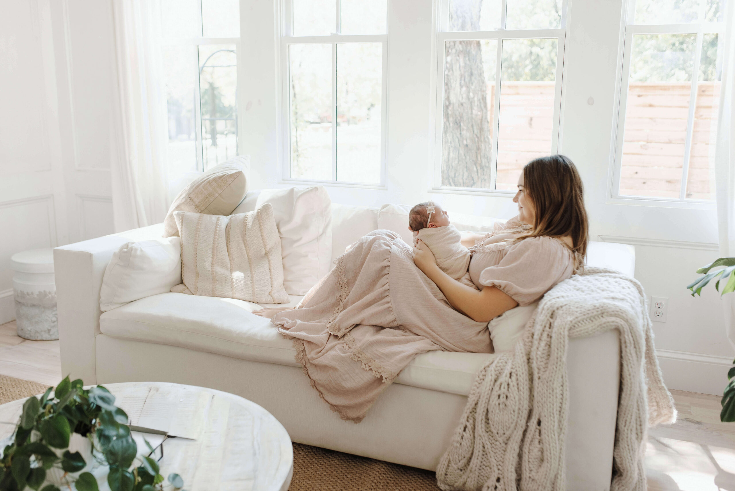 Denton newborn photographer capturing mother and newborn baby in soft natural light during in-home lifestyle session