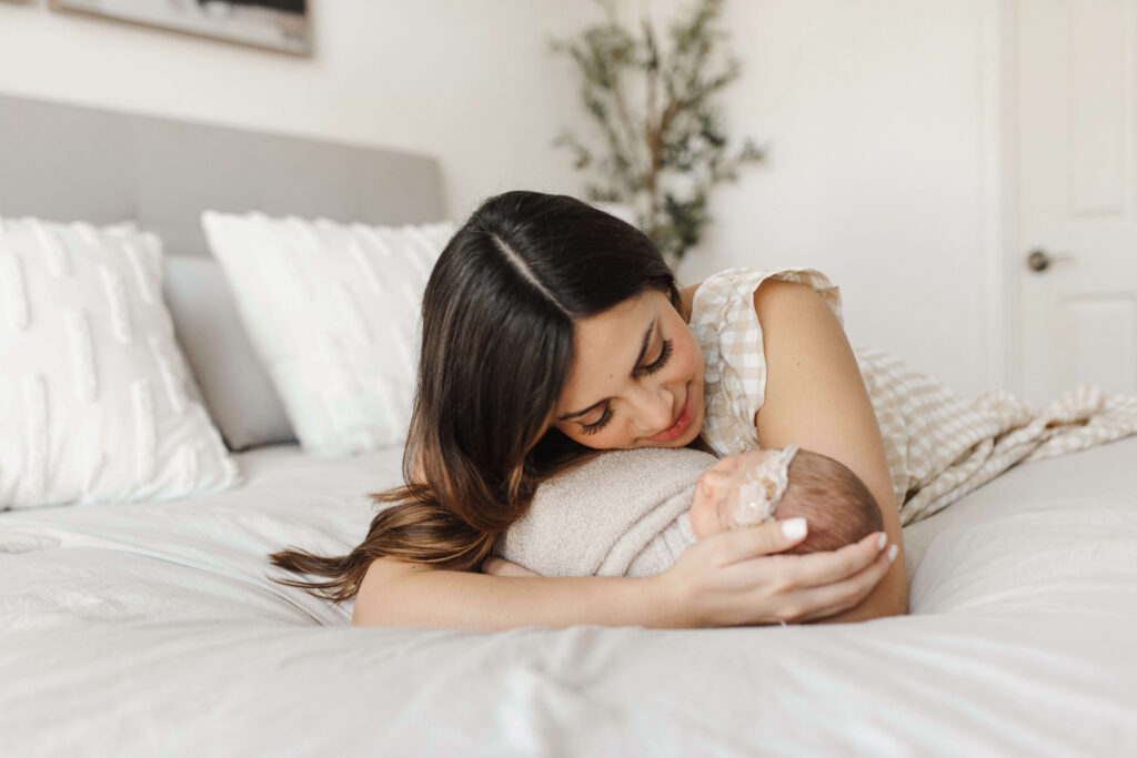 New mom looking at newborn baby, in-home lifestyle newborn session McKinney Texas
