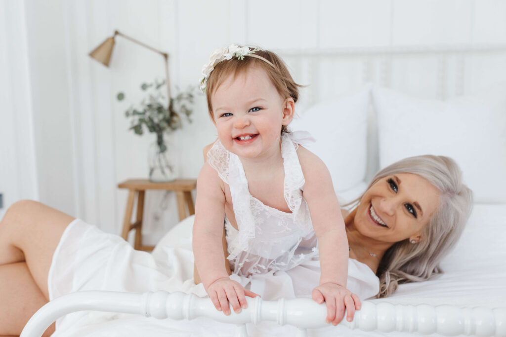 Plano newborn photographer capturing twelve month sitter session with baby sitting up in soft natural light